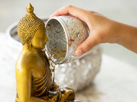 asian child bathing Buddha statuesの写真素材