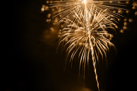 Golden fireworks on dark background.
