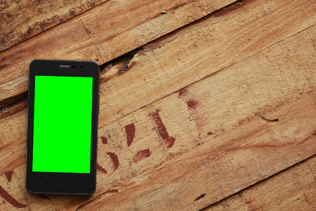 Green screen cell phone on old woodenの写真素材