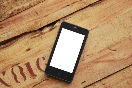 White screen cell phone on old woodenの写真素材