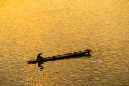 Fisherman on the boat in the middle of the river.の写真素材