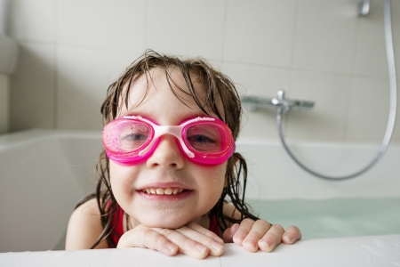  a happy  little girl with swim glasses bathingの写真素材