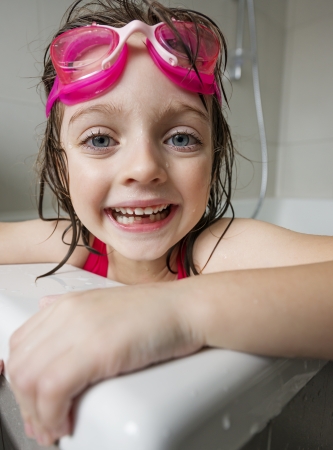 portrait of a  little girl with swim glasses in a bathの写真素材