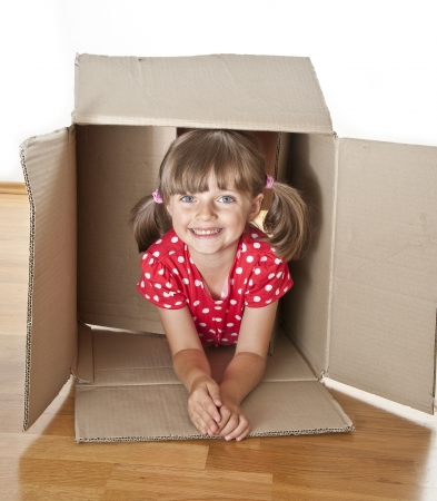 little girl hiden inside a paper boxの写真素材