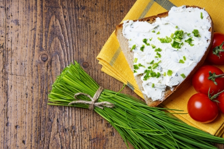 chives and a bread with cottage cheese on a tableの写真素材