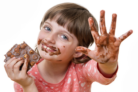little girl eating chocolateの写真素材