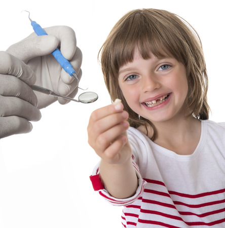 happy little girl pointing her missing teeth in her hand