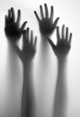 shadow of a hands behind transparent paperの写真素材