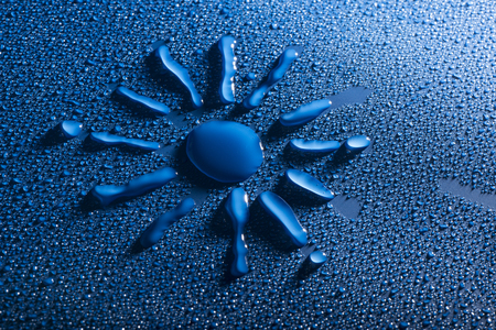 a sun shape between blue water dropsの写真素材