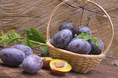 garden plums on a wooden table close upの写真素材