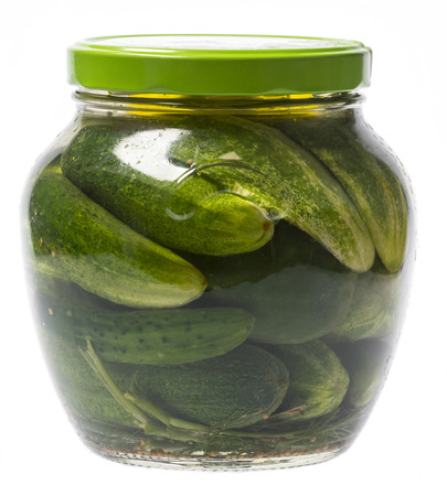 Fermented cucumbers in a glass jar isolated on whiteの写真素材