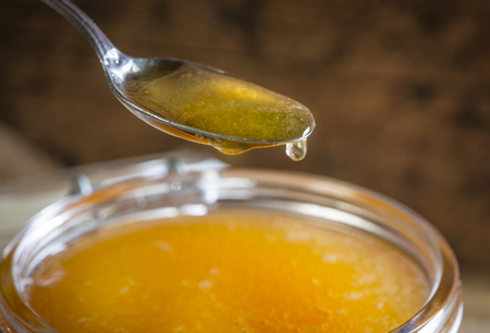 Jar of honey on a wooden table close upの写真素材