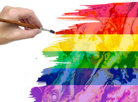 woman hand with paint brush LGBT flag