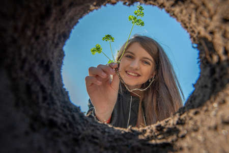 Girl holding seedling - growing in the garden
