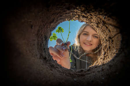 Girl holding seedling - growing in the gardenの写真素材