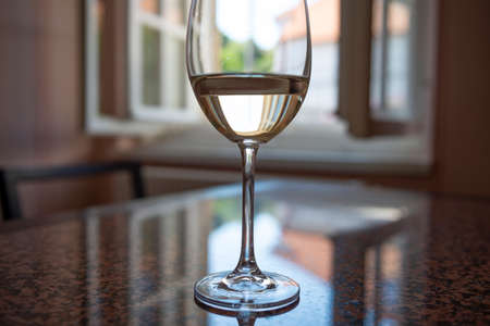 table with glass of vine and open windowの写真素材