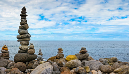 high stack of pebbles on the beach and sea backgroundの写真素材