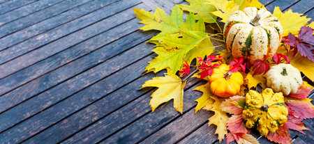 pumpkins and autumn foliage on a wooden tableの写真素材