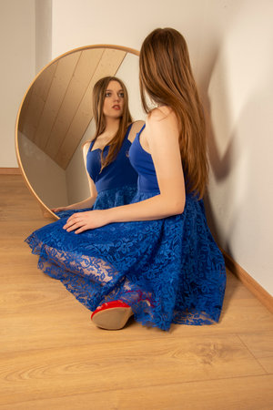 young woman looks in the mirror - art photoの写真素材