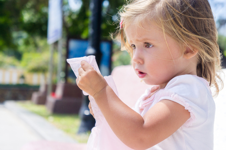 beautiful little girl sitting on the bench.の写真素材