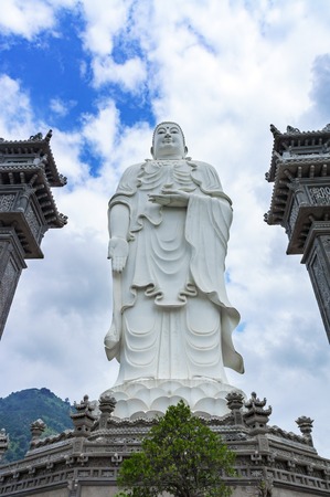 standing white Buddha on a background of blue sky.の写真素材