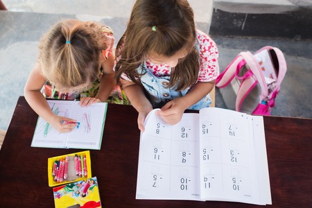 Adorable one little girl drawing artwork top view on crayons in a notebook and girl learn book with mathematicksの写真素材
