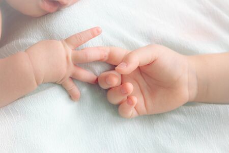 hands of the baby and little girl. two babies hands
