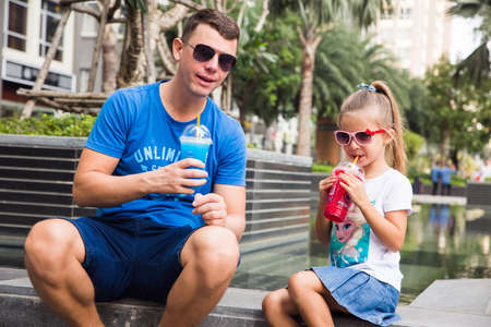 Young girl with her dad have fun, drinking fruit ice Froster.のeditorial素材