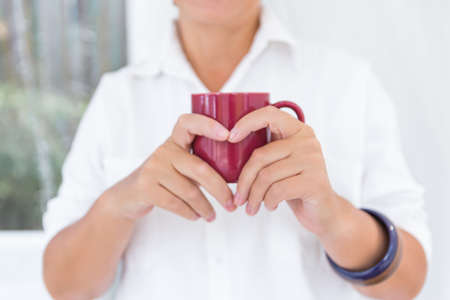 Womans hands holding a cup