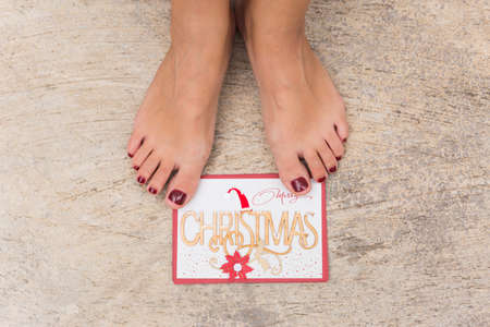 a pair of woman legs and Cristmas card. Merry Christmasの写真素材