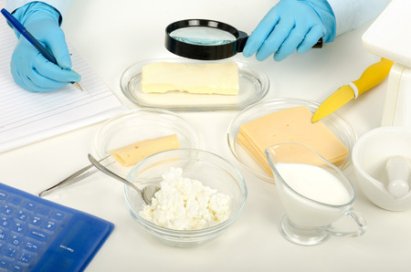 Expert hands inspecting butter with a magnifying glass in phytocontrol laboratoryの写真素材