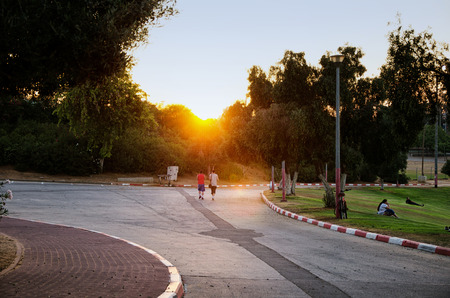Guy couple walking at sunset. Long shot in Amphipark in Rishon Le Zion, Israelのeditorial素材