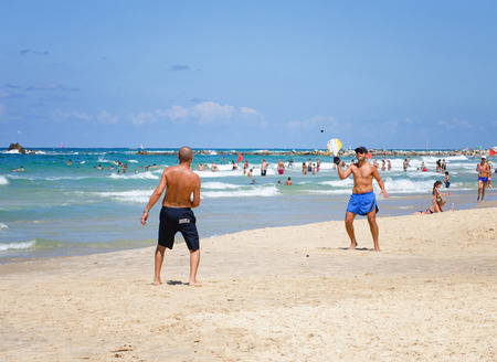 Bat Yam, Israel - September 6, 2014: Two men play in the game likes beach tennis in Bat Yam city, Israel. It is Matkot.  Matkot is a game with no rules, no winners and no losers. In order to succeed, the players must put their full focus in the black rubbのeditorial素材