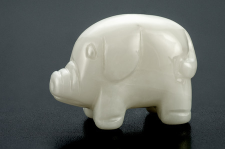 Hand carved white onyx swine on black backgroundの写真素材