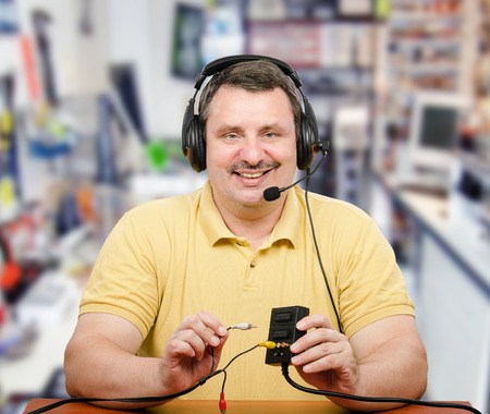 Portrait of computer service technician in headset.  Middle-aged man is consulting via internet.
