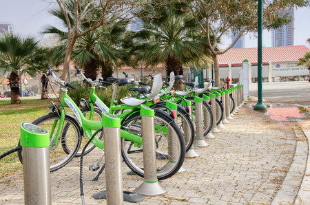 Tel Aviv-Yafo, Israel - January 21, 2016:  City bikes for rent parking in south Tel Aviv area. There are some green short palmsのeditorial素材