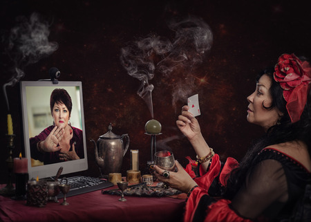 Irritated mature woman says gypsy witch to stop online cartomancy readings. She does not want to know her futureの写真素材