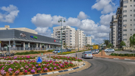 Nes Ziona, Israel-March 20, 2016: Front view of beginning of Avner Ben Ner street. New modern multi-story residential buildings are located on both sides of it. There are supermarket and other commercial stores in left side and beautiful traffic circle inのeditorial素材