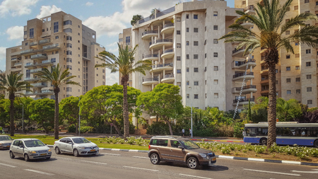 Holon, Israel - May 26, 2016: View of Golda Meir Street. There are cars, white-blue bus moving on...