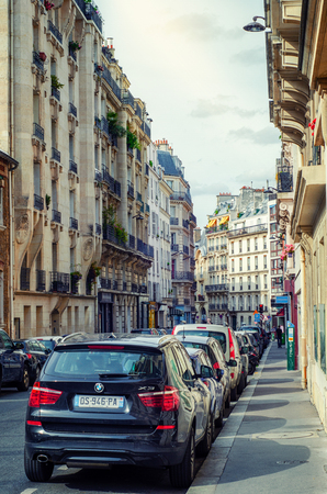 Paris, France - June 4, 2017: Narrow street Henri Barbusse is sandwiched with marvelous old Parisian buildings with parked autos in both sides along of it. Pedestrians are visible in the backgroundのeditorial素材
