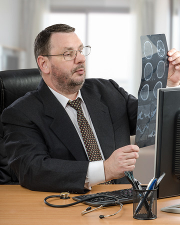 Online an internet physician detailed consultation for patient. Middle aged telemedicine doctor uses CT scan of the brain to get a better look at what was going onの写真素材