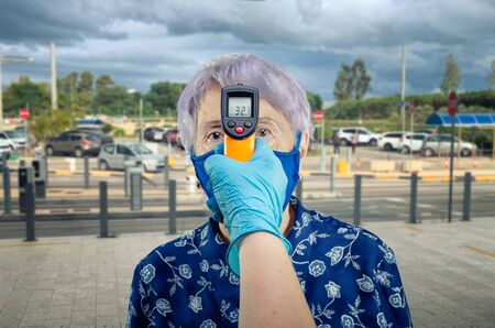 Temperature measurement of an elderly shopper before entering supermarket or mall