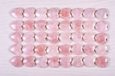 Forty rose quartz hearts are stowed five rows. Eight pieces in each one. Top view.の写真素材