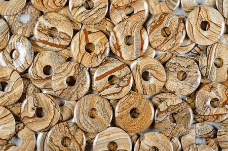 Many donut-shaped semi-precious stones of picture jasper as backgroundの写真素材