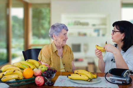On the advice of a doctor geriatric, a senior adult woman began to eat bananas every day. As a result, her blood pressure is back to normal.の写真素材