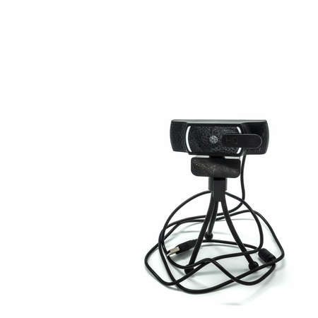 Webcam isolated on a white background. Installed on a small tripod with three flexible legs. USB cable. The lens is covered with a shutter.の写真素材