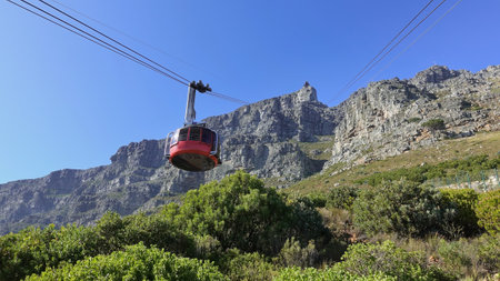 The funicular ascends Table Mountain in Cape Town. Against the background of the blue sky, cables, a...