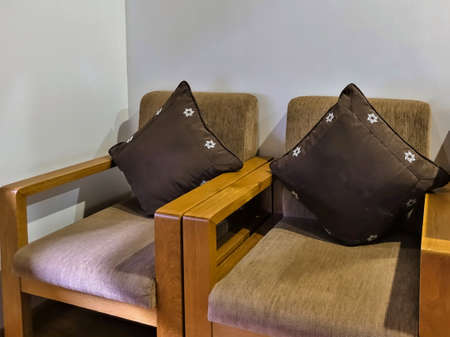 Two soft armchairs upholstered in beige plush. Wooden armrests. The seats are decorated with brown...