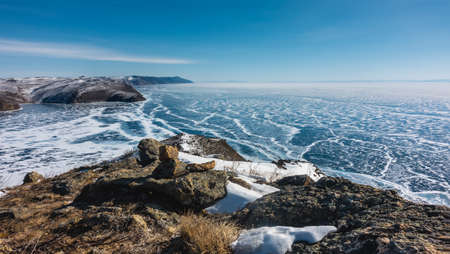 The frozen lake is covered with an openwork snow pattern. In the foreground there are picturesque...