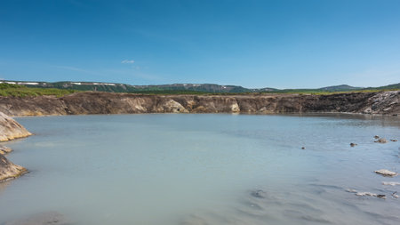 A lake in the caldera of an extinct volcano. Translucent blue water, steep banks. A mountain range...